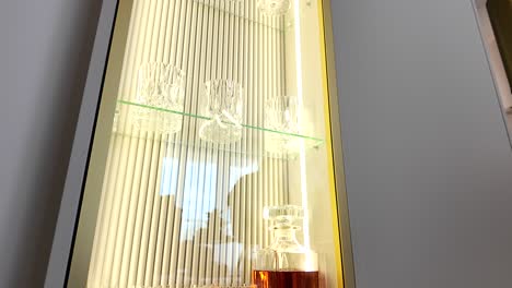 Eine-Flasche-Whisky-In-Einer-Vertikalen-Glasvitrine-Mit-Gläsern-Alkohol