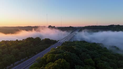 Toma-Aérea-Del-Sol-Matutino-Golpeando-La-Niebla-Sobre-El-Río-Kentucky-A-Lo-Largo-De-La-Carretera-Interestatal-75