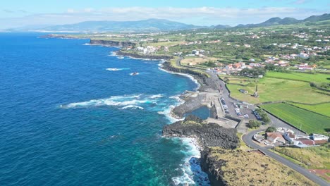 Coastal-town-Mosteiros-on-São-Miguel-island,-Azores,-wide-aerial-pan