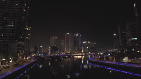 Toma-Panorámica-De-Edificios-Altos-Y-Hoteles-Durante-La-Noche-En-La-Zona-De-Dubai-Marina-De-Los-Emiratos-Árabes-Unidos