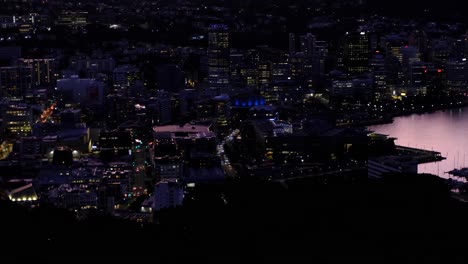 Traffic-with-headlights-driving-through-the-streets-of-Wellington-city-in-New-Zealand-Aotearoa-at-night-time-with-city-lights