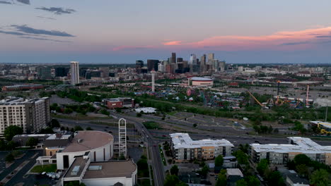 Vista-Aérea-Del-Crepúsculo-Desde-Un-Dron-Sobre-La-I-25-Del-Parque-De-Atracciones-Elitch-Gardens-En-El-Centro-De-Denver