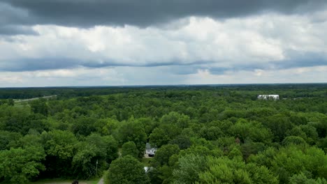 Expansive-aerial-footage-of-a-lush-forest-under-a-dramatic-cloudy-sky