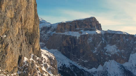 Detailed-close-up-of-towering-rocky-cliffs-with-a-breathtaking-view-of-snowy-mountains-in-the-background