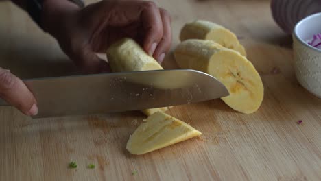 Schneiden-Sie-Stücke-Von-Gelben-Kochbananen-Und-Spezielle-Zutaten,-Um-Eine-Mahlzeit-Zu-Kochen-Zwei-Dosen-Bohnen-Reis-Kochbananen-Avocado-Rote-Zwiebel-Und-Koriander