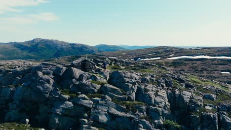 A-Man-Standing-Next-to-a-Steinbua-in-Indre-Fosen,-Trøndelag,-Norway---Pan-Up-Shot