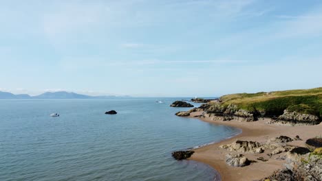 Aerial-view-flight-along-Ynys-Llanddwyn-peaceful-Welsh-island-beach-coastline