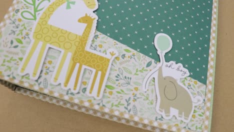 Scrapbook-Album-Mit-Babymotiv-Und-Giraffen--Und-Elefantenmotiv-Im-Cartoon-Stil-Auf-Der-Titelseite