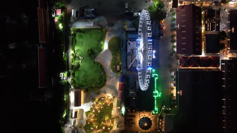 Top-down-drone-shot-over-the-night-lit-Asiatique-Sky-wheel,-in-Bangkok,-Thailand