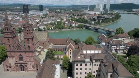 Vídeo-De-Dron-En-4K-De-Una-Hermosa-Iglesia-A-Orillas-Del-Río-Rin-En-El-Centro-De-Basilea,-Suiza