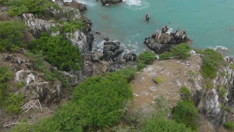 Vista-Aérea-Giratoria-Del-Agua-Del-Mar-Salpicando-Al-Golpear-Las-Rocas-En-La-Costa