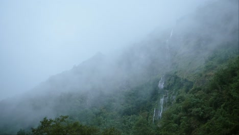 Rainforest-Waterfall-Nature-Background-with-Copy-Space-for-Text,-Moody-Blue-Atmospheric-Mood-Tropical-Scenery-with-Waterfalls-in-Mist-and-Green-Trees,-Mysterious-Background-with-Copyspace