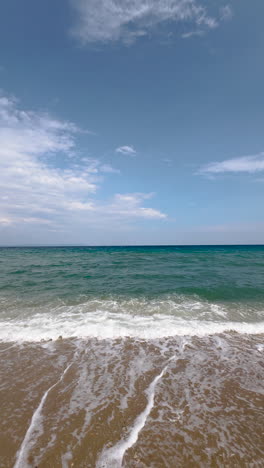 Sea-waves-and-foam-on-sandy-beach,-vertical-video