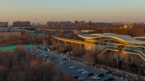 Real-shot-sunset-traffic-flow-Cityscape-with-car-parking-near-trains-railroad-station