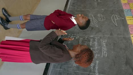 African-Boy-Gets-Approval-From-Teacher-At-School---Vertical-Shot