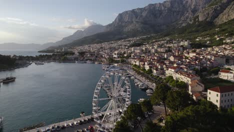 Vista-Aérea-De-La-Noria-Y-Los-Barcos-Al-Amanecer-En-El-Puerto-De-Ferry-De-Makarska,-Croacia