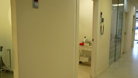 Panning-right-shot-of-a-dental-clinic-corridor-with-several-rooms-and-medical-equipment-visible