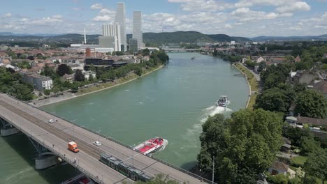 4K-Drone-Video-of-Tugboat-Pulling-Petroleum-Barge-Under-the-Wettsteinbrücke-Bridge-over-the-Rhine-River-in-Basel,-Switzerland