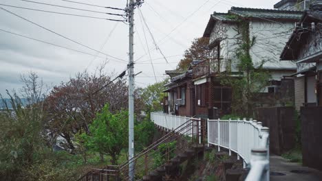 Traditional-Japanese-houses-on-a-hillside-pathway-in-Saikazaki-with-overcast-sky