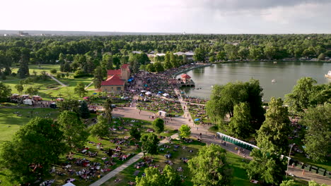 Arcing-aerial-view-over-City-Park-Jazz-event-with-crowds-on-Ferril-Lake-Denver