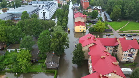 City-infrastructure-under-water,-flooded-main-road,-houses,-traffic-stop,-aerial