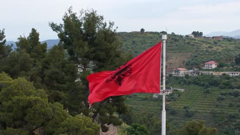 Flag-of-Albania-with-agricultural-landscape-background