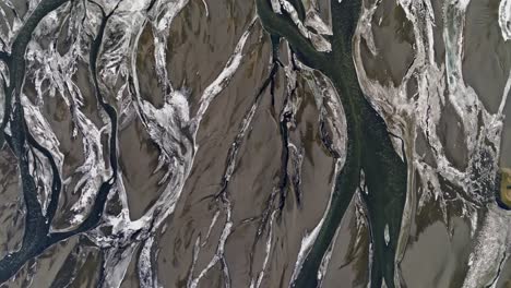 Amazing-meltwater-channels-in-Iceland,-abstract-brown-and-white-pattern,-drone