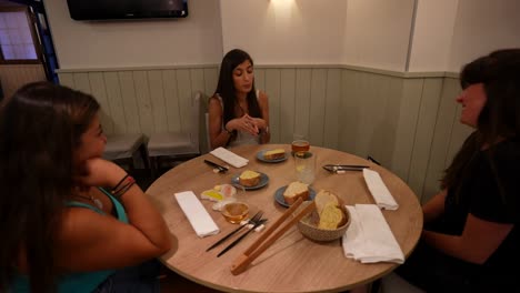 Three-women-enjoy-a-friendly-and-serious-conversation-in-a-cozy-restaurant-setting