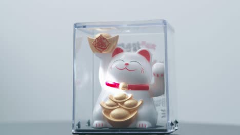 Maneki-Neko,-招き猫,-Katzenruf.-Wörtlich-Bewegt-Die-Japanische-Oder-Chinesische-Glückskatze-Ihre-Pfote-Als-Zeichen-Für-Wohlstand-Und-Reichtum,-Beleuchtet-Von-Der-Sonne-Und-Angetrieben-Von-Einem-Solarpanel.