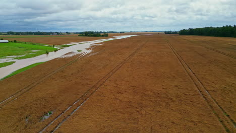 Un-Dron-Sobrevuela-Campos-Agrícolas-Inundados,-Después-De-Una-Lluvia-Torrencial,-En-Un-Día-Nublado