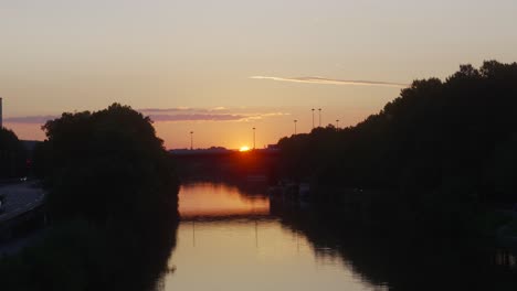 Puesta-De-Sol-Sobre-El-Río-Sarre,-Saarbrücken,-Alemania,-Amanecer,-Reflejo-Del-Sol-En-El-Agua