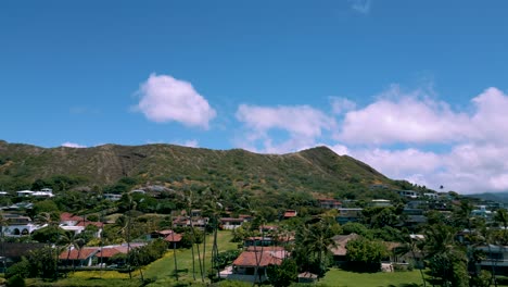 Aerial-static-view-of-Diamond-head-behind-homes-in-Kahala-Oahu-Hawaii-as-clouds-pass-over-on-blue-sky