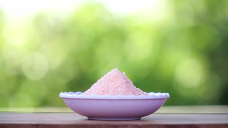 Pink-himalayan-salt-on-the-white-bowl-and-nature-blur-background