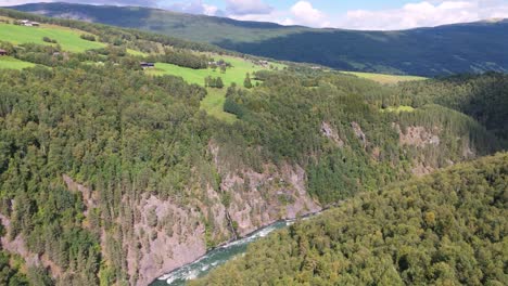 Luftaufnahme-Eines-üppig-Grünen-Tals-Mit-Einem-Fluss,-Der-Durch-Dichte-Wälder-Fließt-Und-Die-Natürliche-Schönheit-Und-Die-Ruhige-Landschaft-Der-Region-Hervorhebt