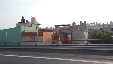 Driving-Highway-POV-at-Villa-31-Favela-style-low-ghetto-in-Buenos-aires-City-Argentina,-colorful-poor-class-architecture-in-metropolitan-south-american-capital