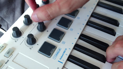 Beautiful-slow-motion-close-up-shot-of-a-young-man's-hands-playing-the-Arturia-Minilab-2-keyboard-and-moving-the-knobs-to-generate-musical-effects