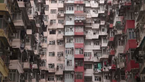 Antiguo-Edificio-De-Apartamentos-Residenciales-Densos-Con-Balcones-Y-Ventanas,-Barrio-De-Hong-Kong,-Inclinación-Hacia-Arriba