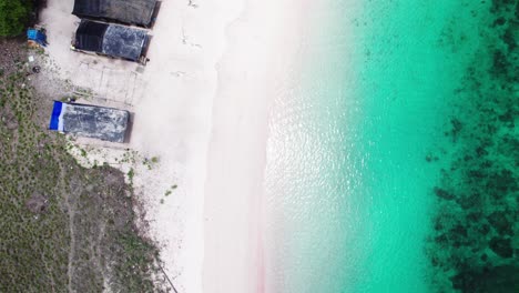 Entdecken-Sie-Die-Bezaubernde-Schönheit-Des-Pink-Beach-Im-Komodo-Nationalpark-Aus-Der-Vogelperspektive-Und-Bewundern-Sie-Den-Atemberaubenden-Rosa-Sand-Und-Das-Leuchtend-Türkisfarbene-Wasser