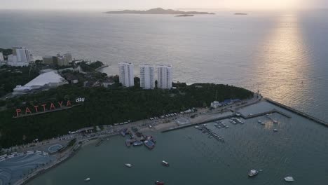 Dron-Sobre-Pattaya,-Tailandia,-Vista-Aérea-Al-Atardecer-Con-Vista-Al-Muelle-Del-Ferry-De-Destino-De-Vacaciones-De-La-Isla-Ko-Lan-Y-El-Letrero-De-La-Ciudad