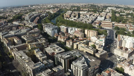 High-angle-aerial-trucking-pan-above-Trastevere-neighborhood-Rome-Italy-as-cars-drive-along-shaded-roads