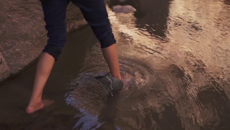 Walking-barefoot-in-water-between-rocks