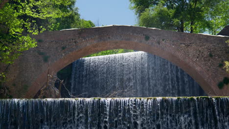 Puente-De-Arco-De-Piedra-Histórico-Palaiokarya-Grecia-Cascada-Cámara-Lenta-Día-Soleado-Toma-Estática