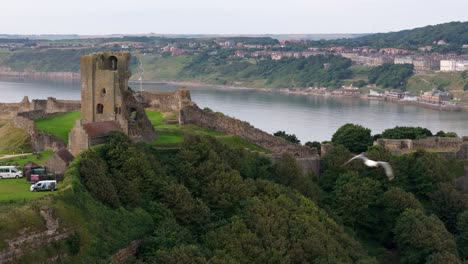 Aerial-drone-view-of-Scarborough-Castle-in-Scarborough,-North-Yorkshire-taken-early-morning-on-an-overcast-day-in-summer