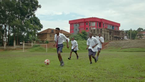 Niños-Africanos-Con-Uniforme-Escolar-Jugando-Al-Fútbol-Durante-El-Día-En-Uganda