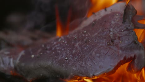 Koch-Macht-Lendensteak-Auf-Offenem-Grill-Durch-Klopfen-Auf-Den-Grill-Zart,-Bevor-Er-Es-Mit-Rauch-Und-Feuer-In-Zeitlupe-4k-Wendet