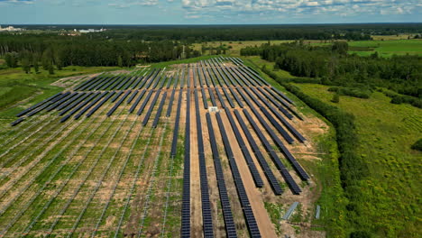 Aerial-view-circling-a-solar-power-park-construction-site,-sunny,-summer-day