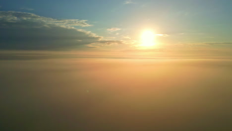 Sunset-over-dense-fog,-dusk-setting-down,-beautiful-skyline-aerial-time-lapse