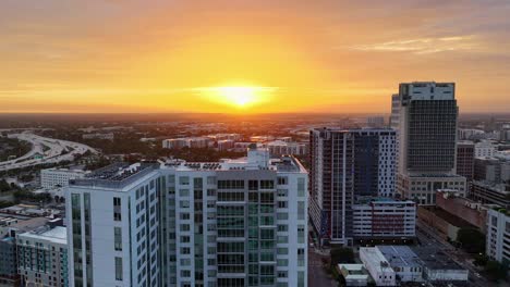 Toma-Aérea-De-Un-Dron-Que-Sigue-A-La-Izquierda-Pasando-Por-Los-Rascacielos-Durante-El-Amanecer-En-Tampa