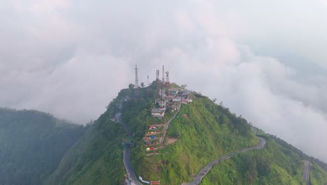 Aerial-view-of-mountain-with-green-vegetation-and-a-road-built-in-a-circle-to-the-top