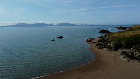 Luftaufnahme-über-Den-Wunderschönen,-Friedlichen-Walisischen-Inselstrand-Und-Die-Bergkette-Von-Ynys-Llanddwyn